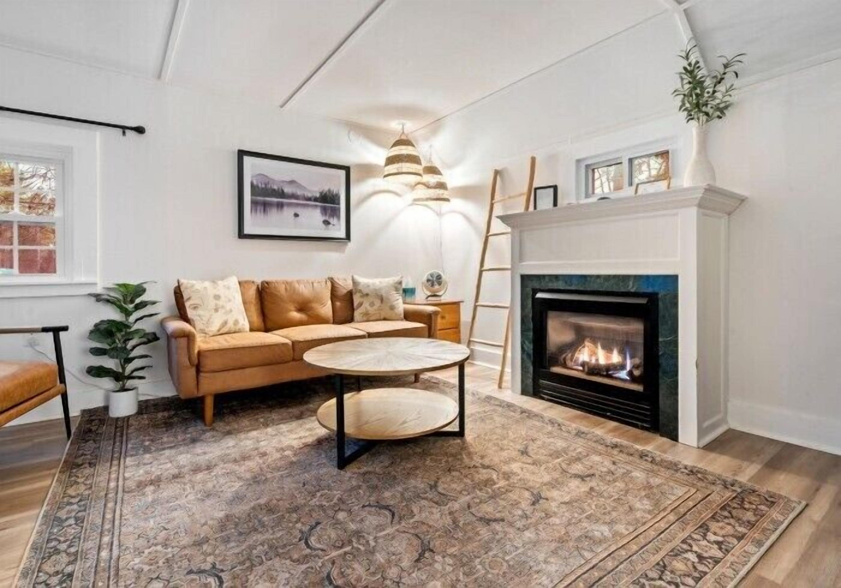 A living room with a fireplace, a sofa, a coffee table, and a rug.