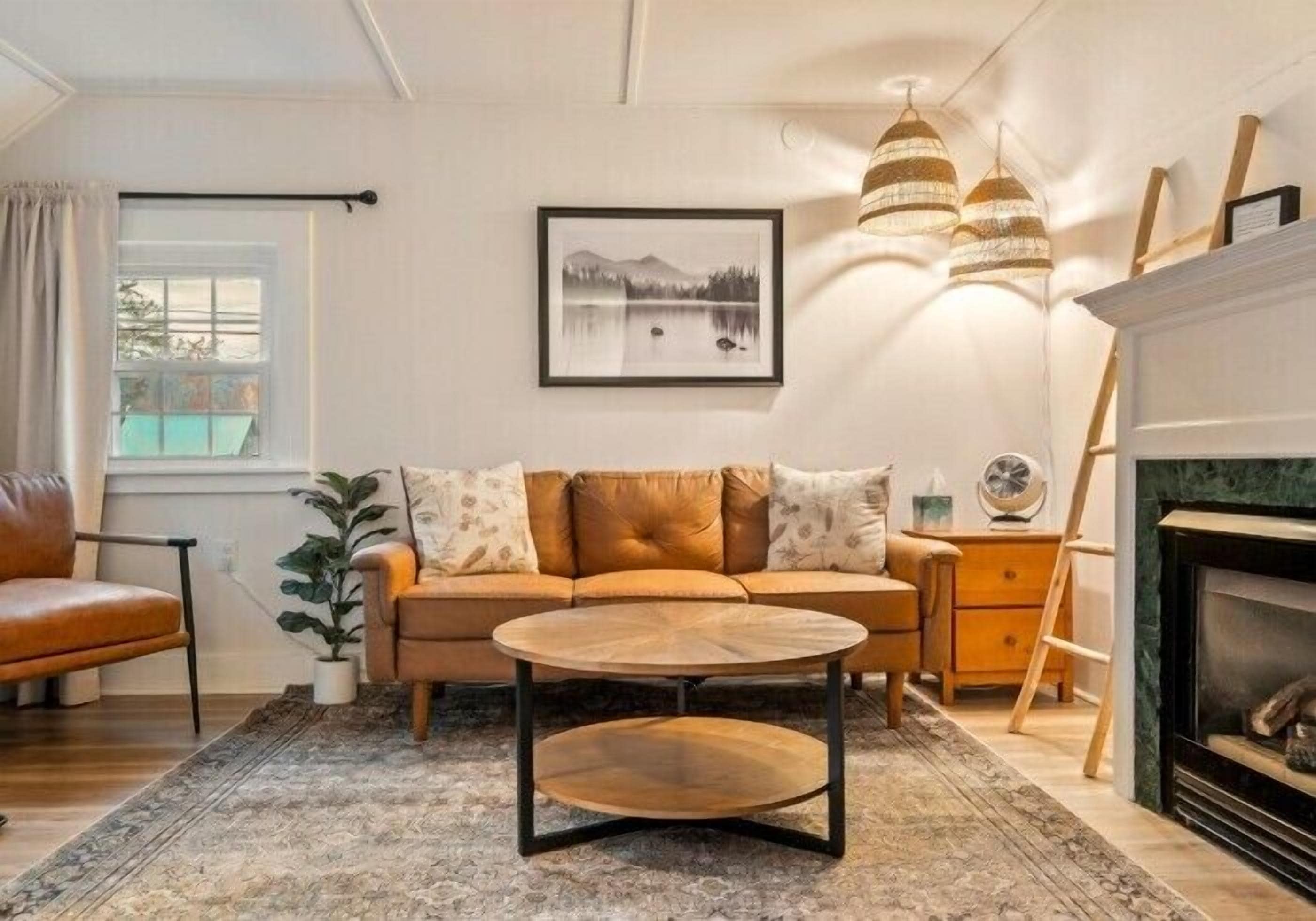 A living room with a sofa, a coffee table, a fireplace, and a framed picture on the wall.