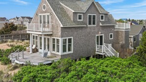 A two-story house with a balcony, a covered porch, and a deck.