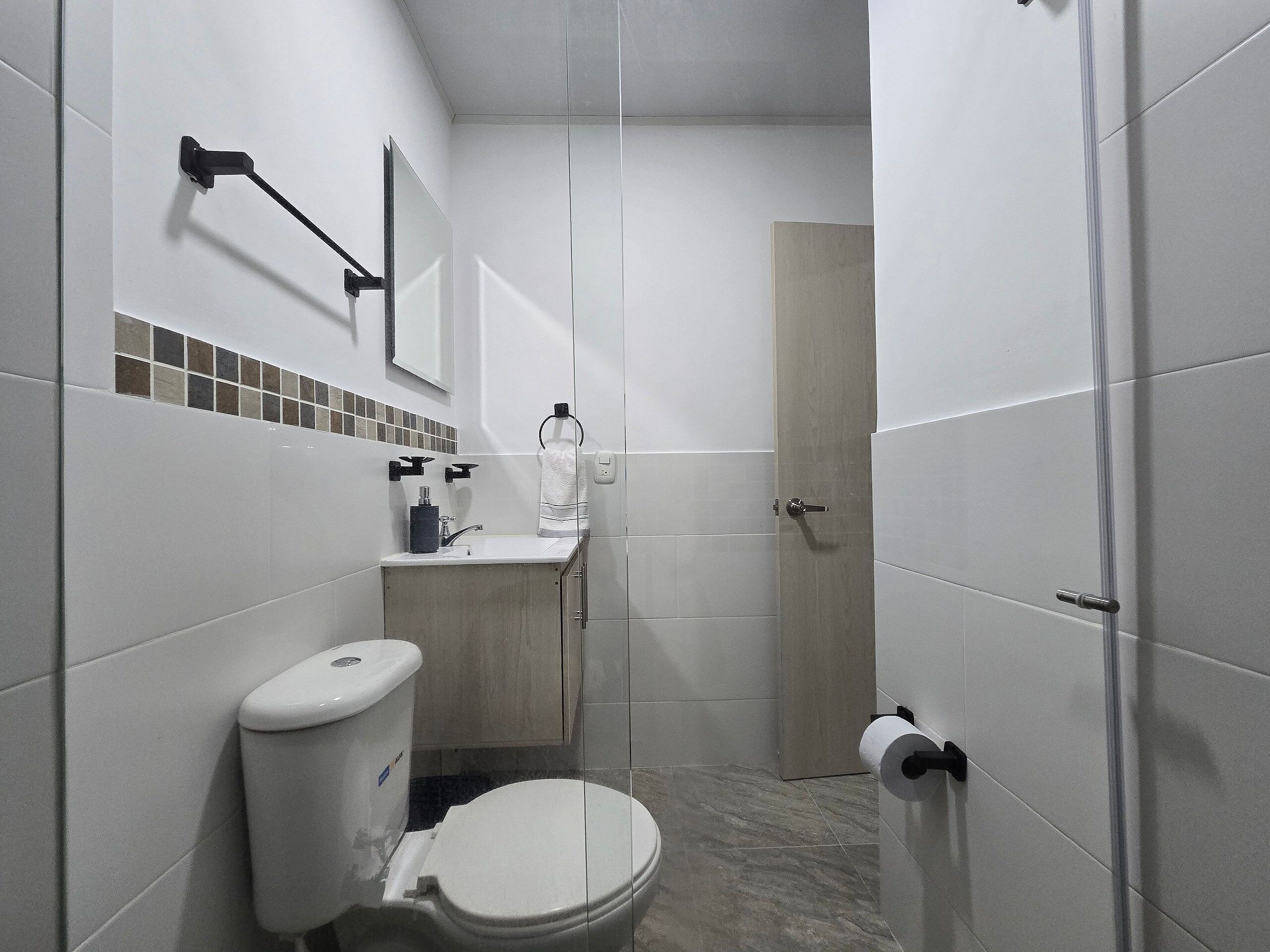 Une salle de bain moderne avec des toilettes, un lavabo et un miroir.