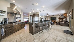 Una cocina amplia con una isla grande, un comedor y una sala de estar con chimenea.