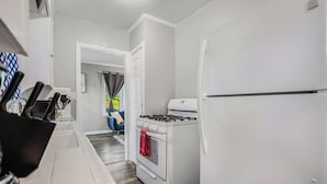 A modern kitchen with white appliances, a gas stove, and a refrigerator.