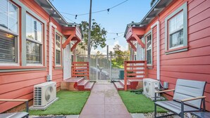 A residential property with two red houses, a paved pathway, and outdoor seating.
