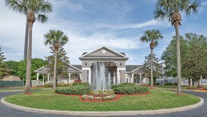 A building with a central fountain, surrounded by palm trees and a landscaped garden. - Disney Fab4, Stitch, Lady!Come enjoy a Magical vacation so close to WDW and more (Kissimmee)