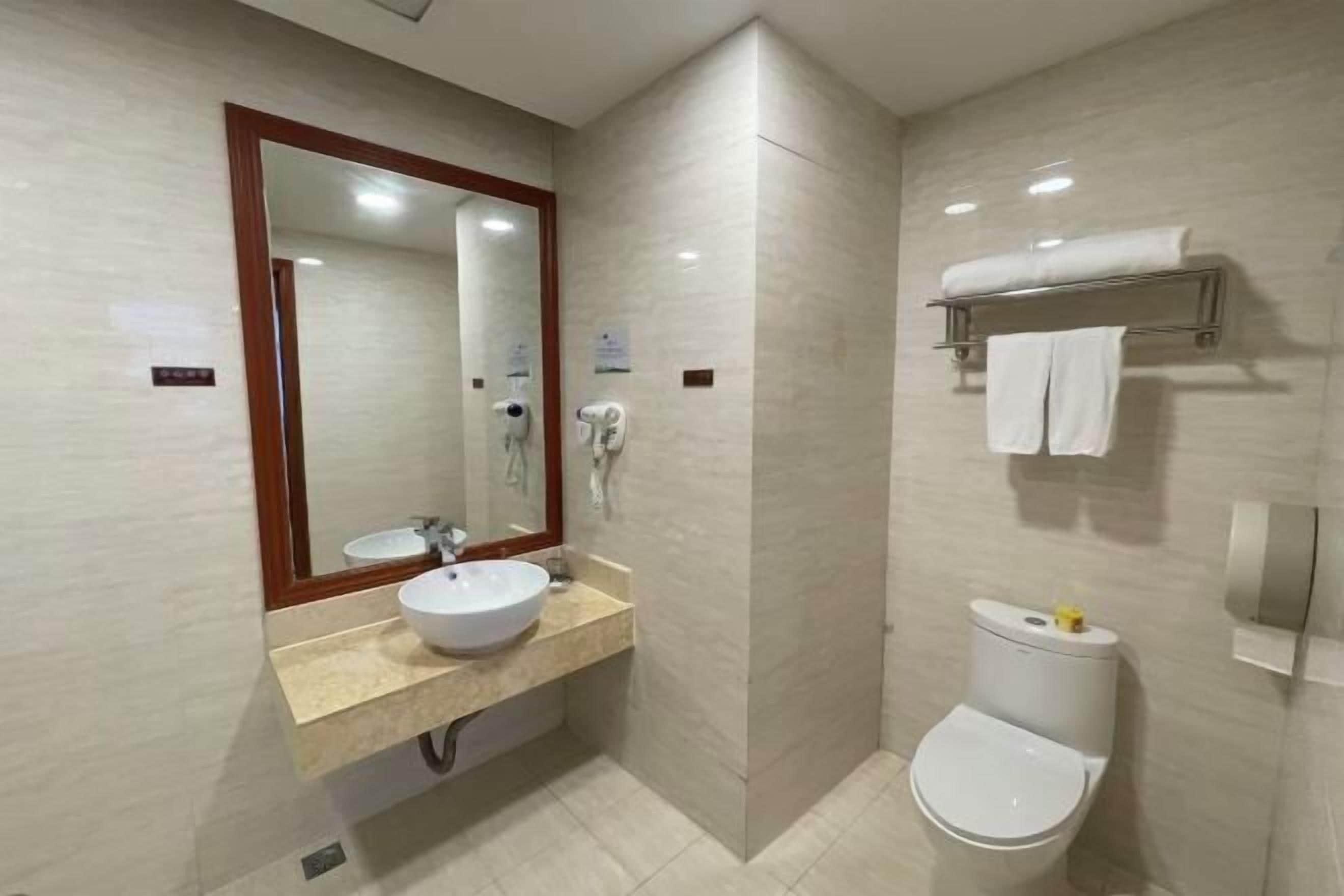 Un baño pequeño con lavamanos, espejo y retrete.