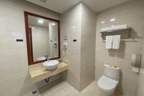 Un baño pequeño con lavamanos, espejo y retrete.