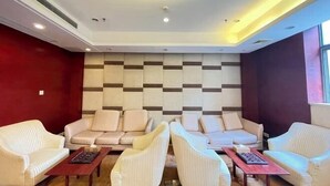 A modern living room with sofas and armchairs arranged around a central coffee table.
