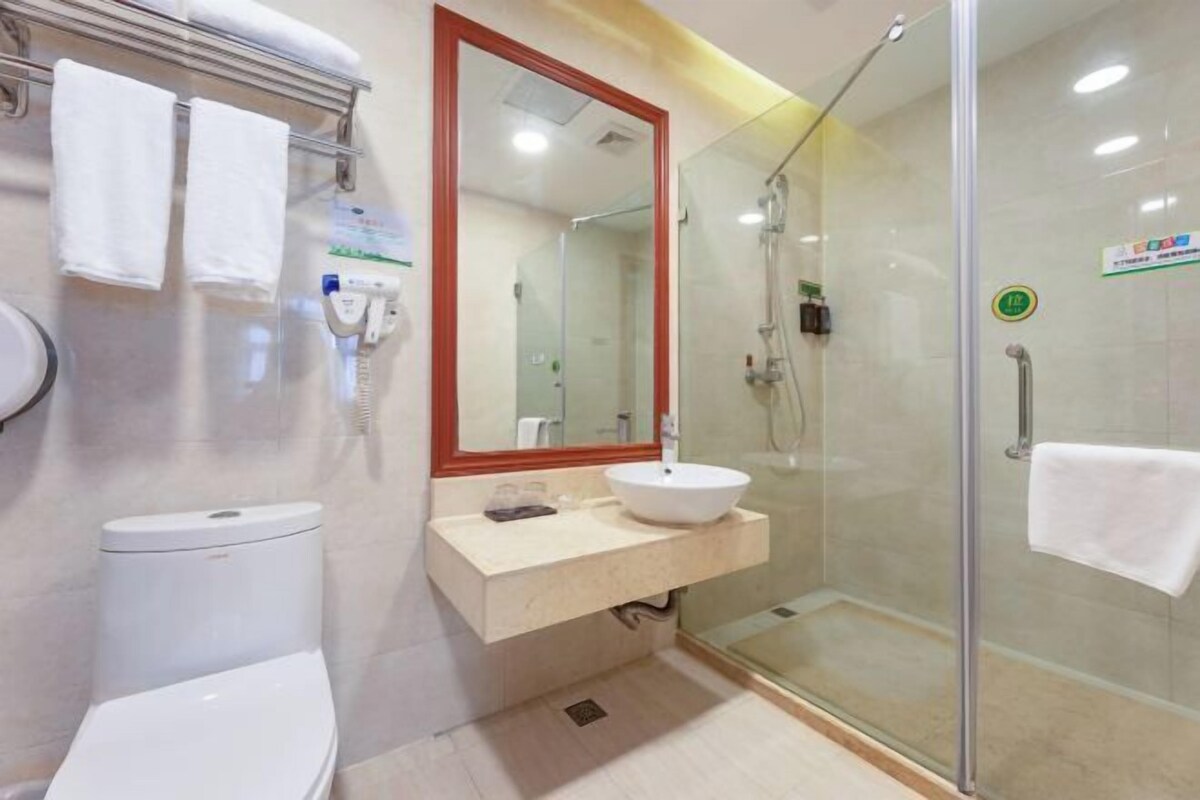 A modern bathroom with a toilet, sink, and glass-enclosed shower.