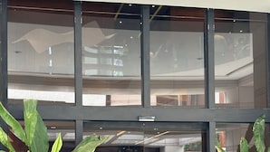 Entrada de un edificio con grandes puertas de vidrio, plantas en macetas a cada lado y un letrero que dice "Radisson Sao Paulo".
