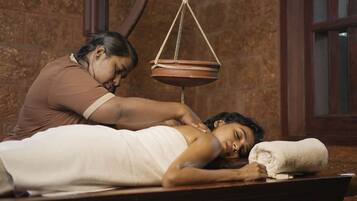 Experience a traditional massage therapy session in a serene room with a wooden floor and a focus on holistic practices.