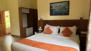 A hotel room with a large bed, a wooden headboard, a painting on the wall, and a wooden chair.