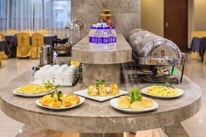 A buffet setup with various food items, a water dispenser, and a coffee machine. - Holiday Inn Huili (Foshan Huili Plaza) (Foshan)