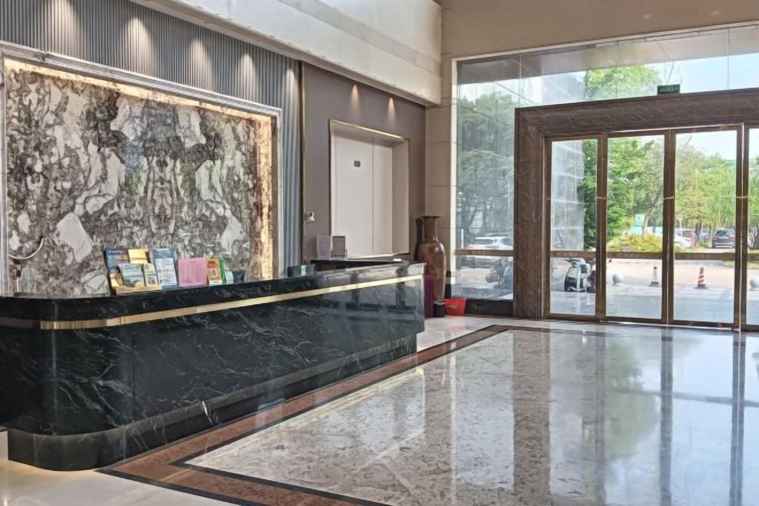 A reception area with a marble counter, a door, and a view of the outside.