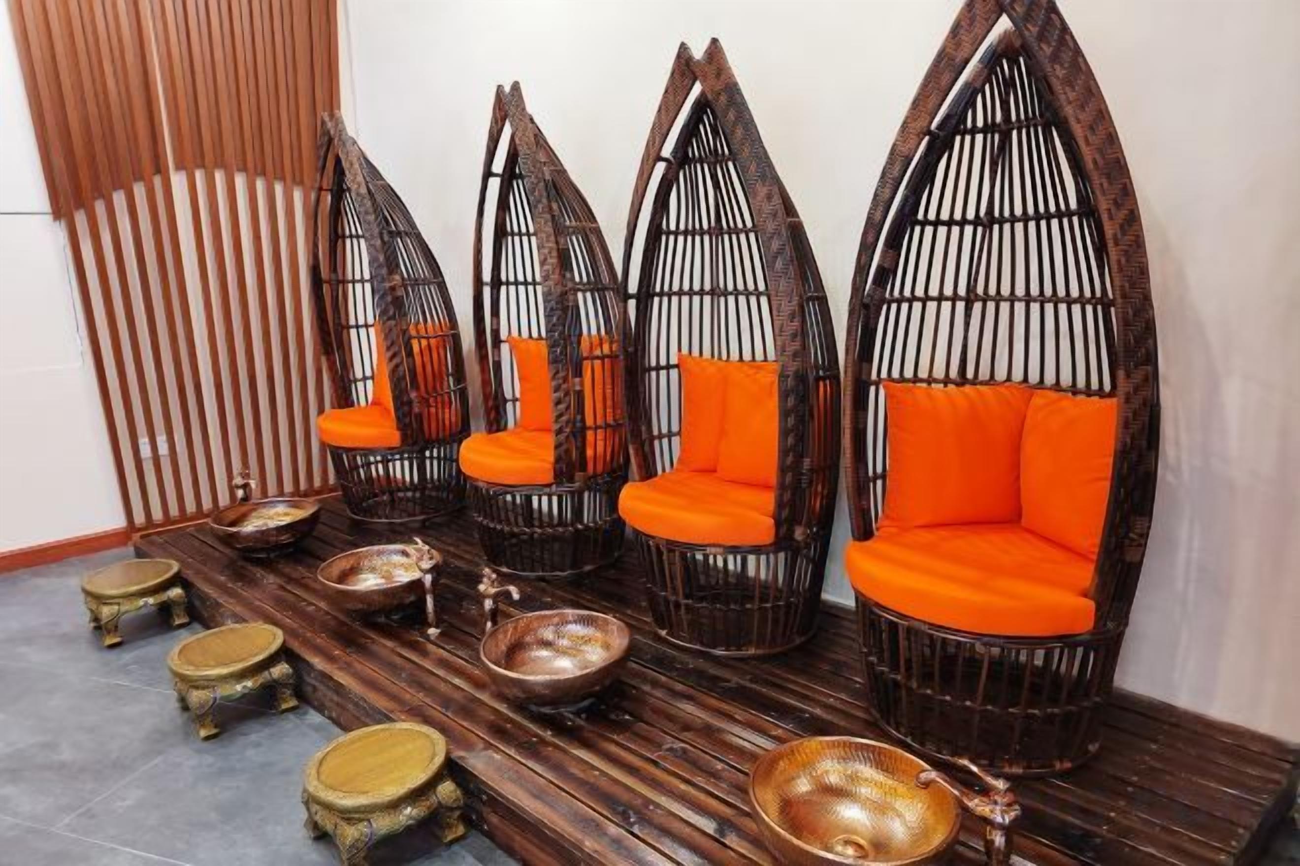 A seating area with multiple chairs and stools, arranged on a wooden floor.