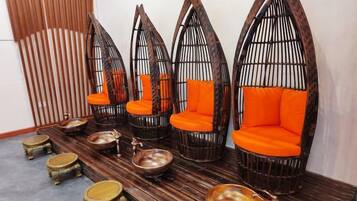 A seating area with multiple chairs and stools, arranged on a wooden floor.