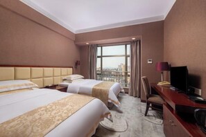 A hotel room with two beds, a desk, a television, and a view of the city through large windows. - Holiday Inn Huili (Foshan Huili Plaza) (Foshan)