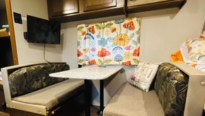 A compact kitchenette with a microwave, a small table, and two cushioned seating areas. - HideOut in The Highlands 
15min from Skyline Trail
Walking distance from Sunsets (Pleasant Bay)
