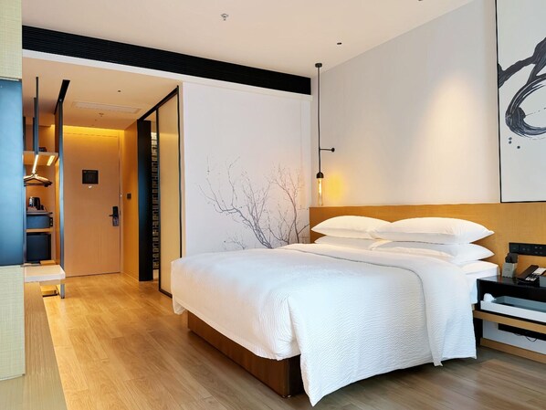 A modern hotel room with a large bed, a wooden floor, a wardrobe, and a desk with a chair. - Fairfield By Marriott Shenzhen Bao'an (Shenzhen)