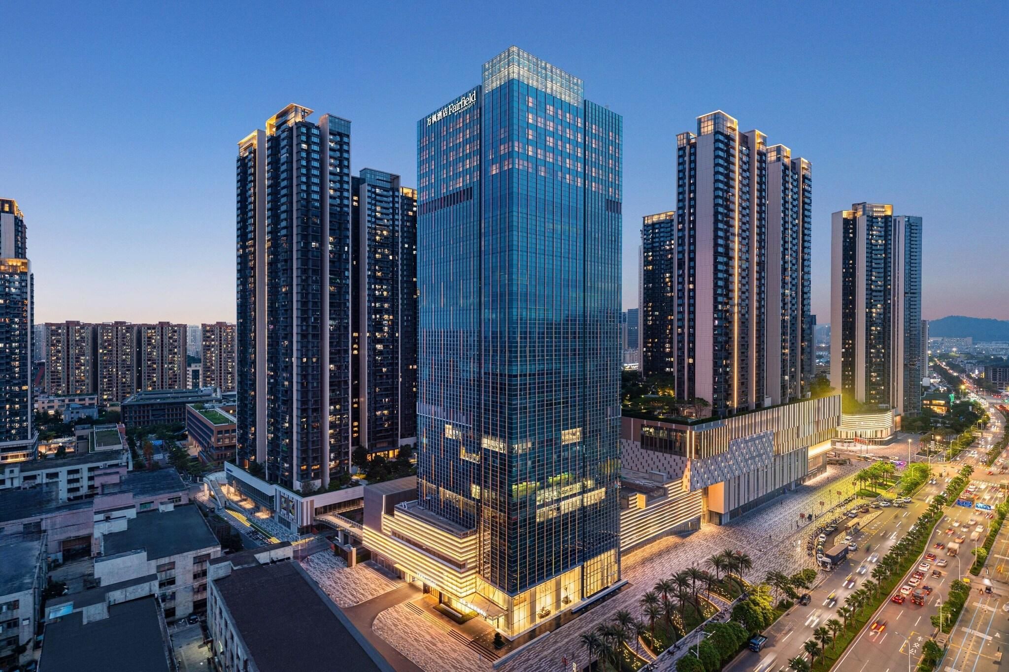 Un immeuble de grande hauteur doté d’une façade moderne en verre, entouré d’autres bâtiments imposants, ce qui témoigne de la densité urbaine de la zone.