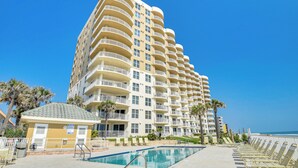 A high-rise hotel with multiple balconies, a swimming pool, and a beach view. - Daytona Beach Condo: Pool Access, Oceanfront (Daytona Beach Shores)