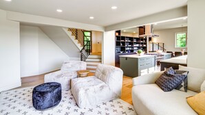 Un interior moderno con una escalera, una cocina y zonas de estar.