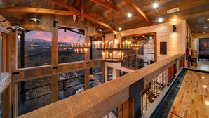 Un intérieur en bois aux plafonds hauts, doté de grandes fenêtres donnant sur un paysage enneigé.
