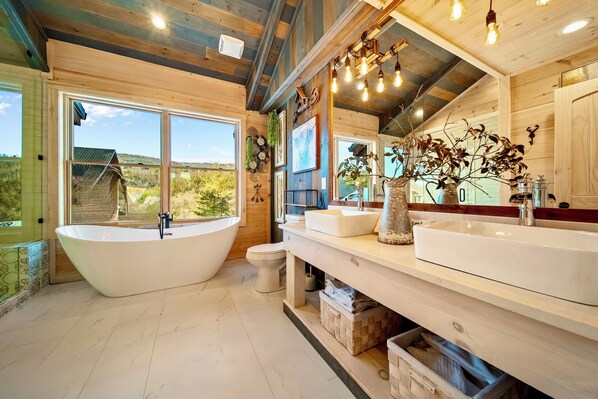 A modern bathroom with a freestanding bathtub, a large mirror, and a sink.