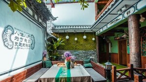 Ein traditionelles chinesisches Restaurant mit einem Essbereich, der Holzbanken und einen Tisch mit einer grünen Tischläufer hat.