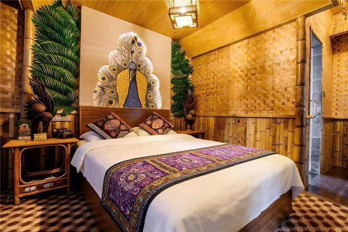 A room with a bed, a wooden headboard, a wall mural, and a woven wall.