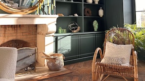 A cozy room with a fireplace, a large mirror, and a wicker chair. - Maison de Charme Pour Événements Familiaux ou Professionnels Domaine Le Pinquat (La Lande-de-Fronsac)