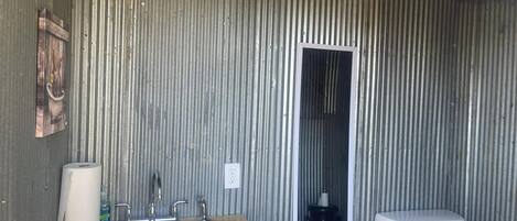 A bathroom with a wooden vanity, a sink, a toilet, and a mirror.