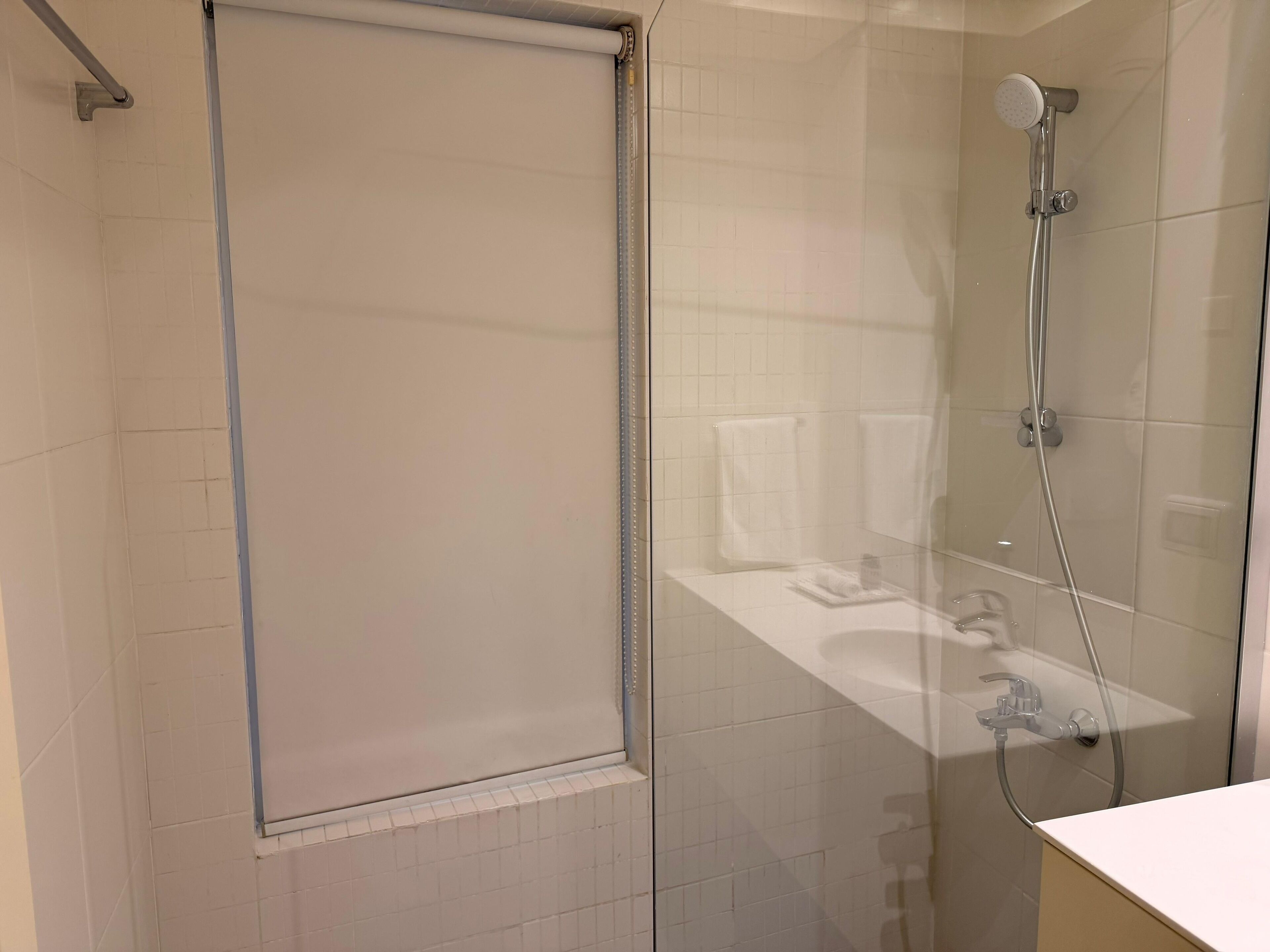 Un bany modern amb dutxa de vidre, mampara de vidre i zona de banyera visible.