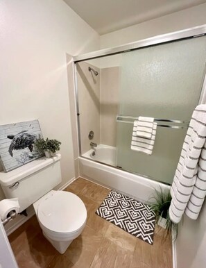 Un baño pequeño con inodoro, ducha y bañera.