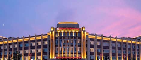 A large, modern hotel with a prominent entrance and illuminated signage.