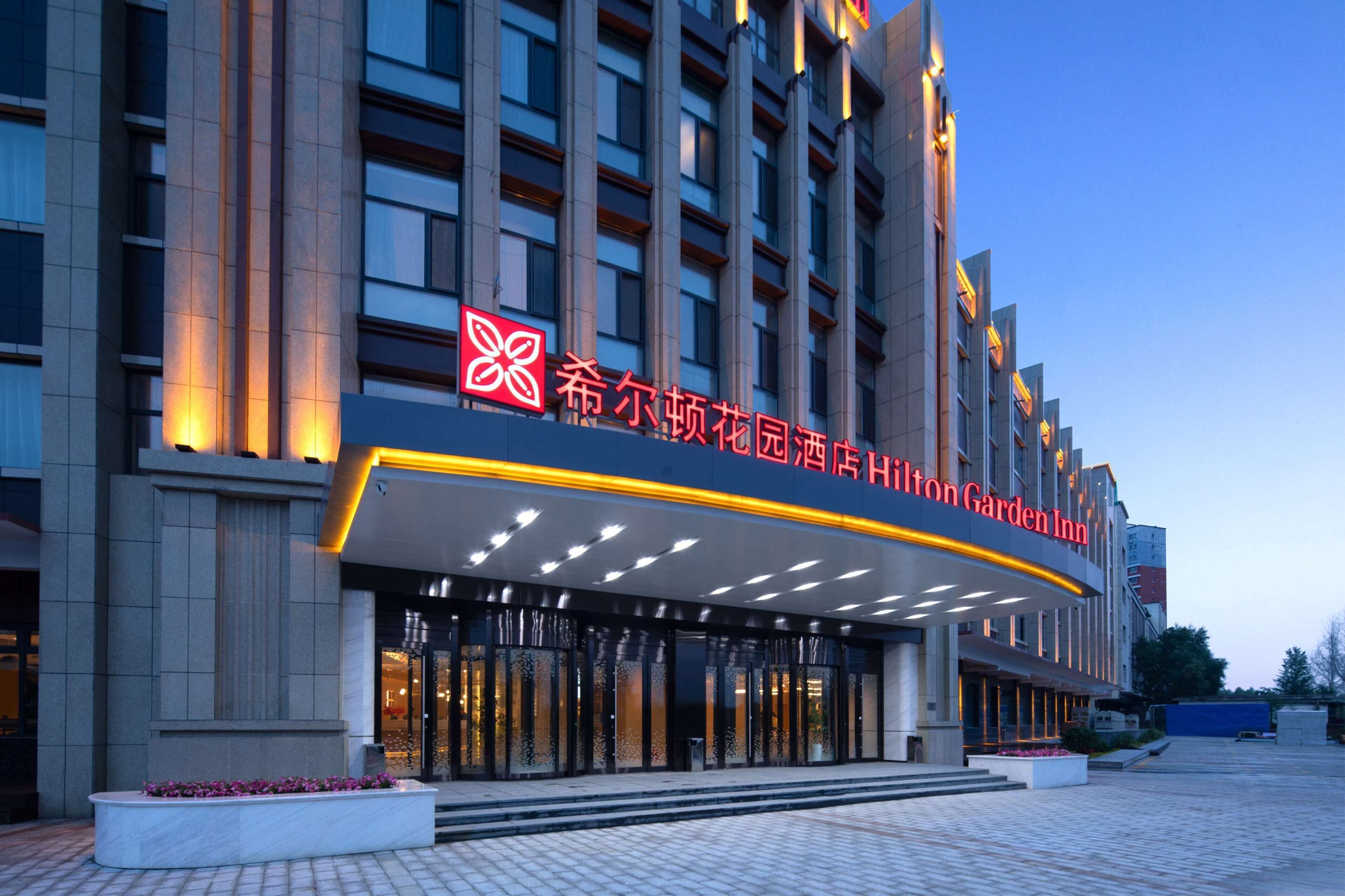 L’entrée d’un hôtel au design moderne, avec une enseigne bien visible et un éclairage soigné.