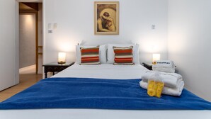 A hotel room with a bed, two bedside tables, a nightstand, a framed artwork above the bed, and a blue blanket on the bed. - For Families 10min From Copacabana Beach Pl804 (Rio de Janeiro)