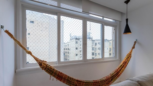 A hammock tied to a window with a view of buildings outside. - For Families 10min From Copacabana Beach Pl804 (Rio de Janeiro)