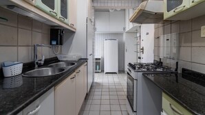 A compact kitchen with a sink, stove, and white cabinets. - For Families 10min From Copacabana Beach Pl804 (Rio de Janeiro)
