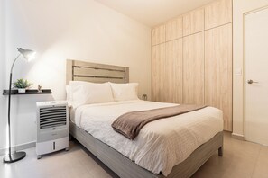 Enjoy a restful night's sleep in this serene bedroom with a comfortable bed, ample storage, and a touch of greenery.