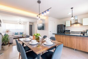 Enjoy meals in this stylish living space with a dining area, kitchen, and comfortable seating.