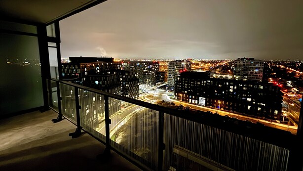 A high-rise building with a view of a cityscape at night.