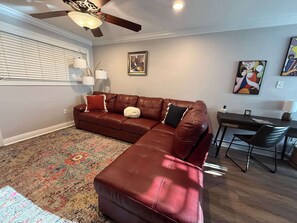 A living room with a sectional sofa, a coffee table, a dining table with chairs, a ceiling fan, and a patterned rug. - Parking | 5 min downtown | WD | TV bedroom | Pool (Baton Rouge)