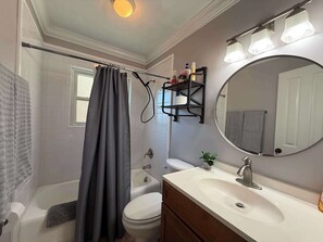 A bathroom with a bathtub, toilet, sink, and a mirror with lights. - Parking | 5 min downtown | WD | TV bedroom | Pool (Baton Rouge)
