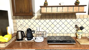 Una encimera de cocina con cafetera, hervidor y procesador de alimentos.