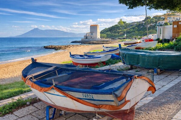 Boats on a beach with a mountain in the background.