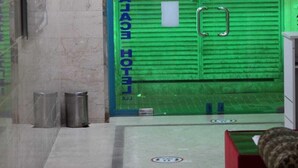 A hotel entrance with a green awning and a sign that reads "WELCOME."