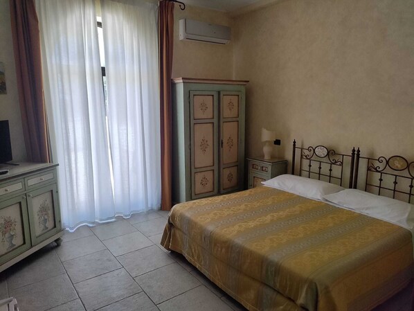 A bedroom with a bed, a dresser, a wardrobe, and a desk.