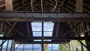 A rustic wooden interior with a large skylight and multiple windows offering views of a mountainous landscape. - Saratoga's Musical Oasis|Heated Pool|King Bed|Mountain Views| (Greenfield center)
