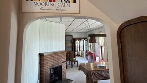 A hallway with a fireplace, a sign above reading 'MOORING CALM', and a wooden door on the right. - Large Waterfront Lake Michigan - Book Fall Colors! (Menominee)