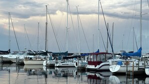 A marina with multiple boats docked, calm water, and a few ducks swimming. - Large Waterfront Lake Michigan - Book Fall Colors! (Menominee)